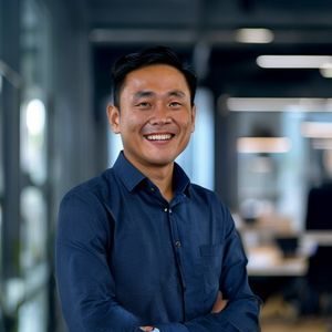 陈海洋，鲍鱼视频创始人兼CEO，身穿深蓝色衬衫，面带自信微笑，站在现代化办公室内，背景是团队工作的开放空间